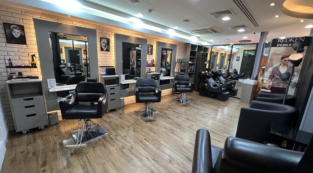 Stylish interior of Version Francaise - Barbershop Gents Salon in Dubai, Dubai, AE, featuring sleek chairs and mirrors.