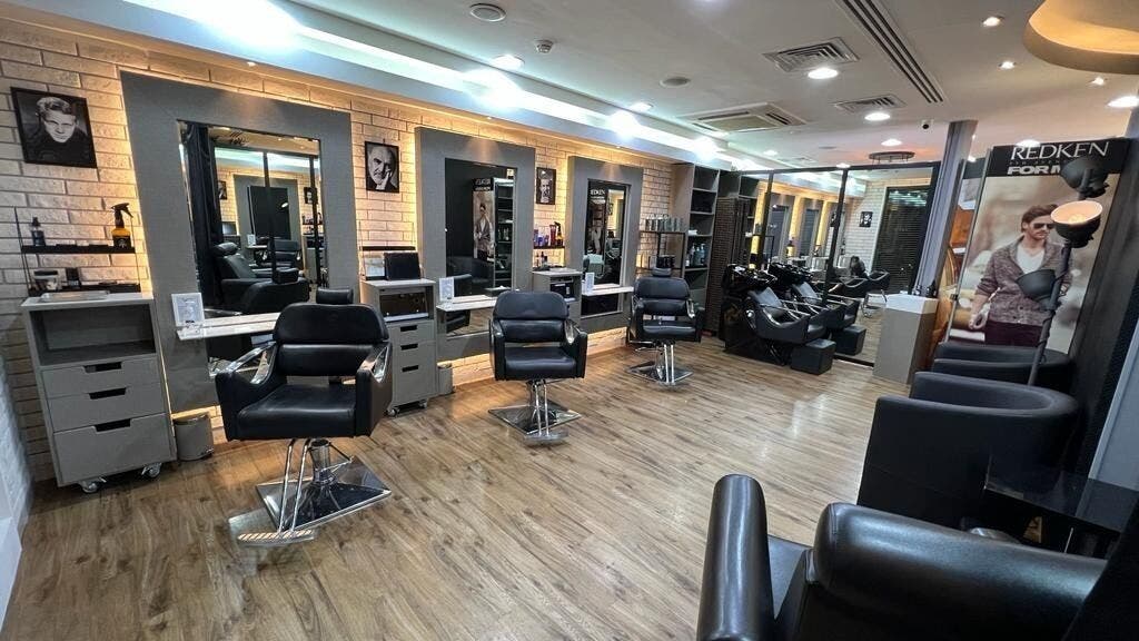 Stylish interior of Version Francaise - Barbershop Gents Salon in Dubai, Dubai, AE, featuring sleek chairs and mirrors.