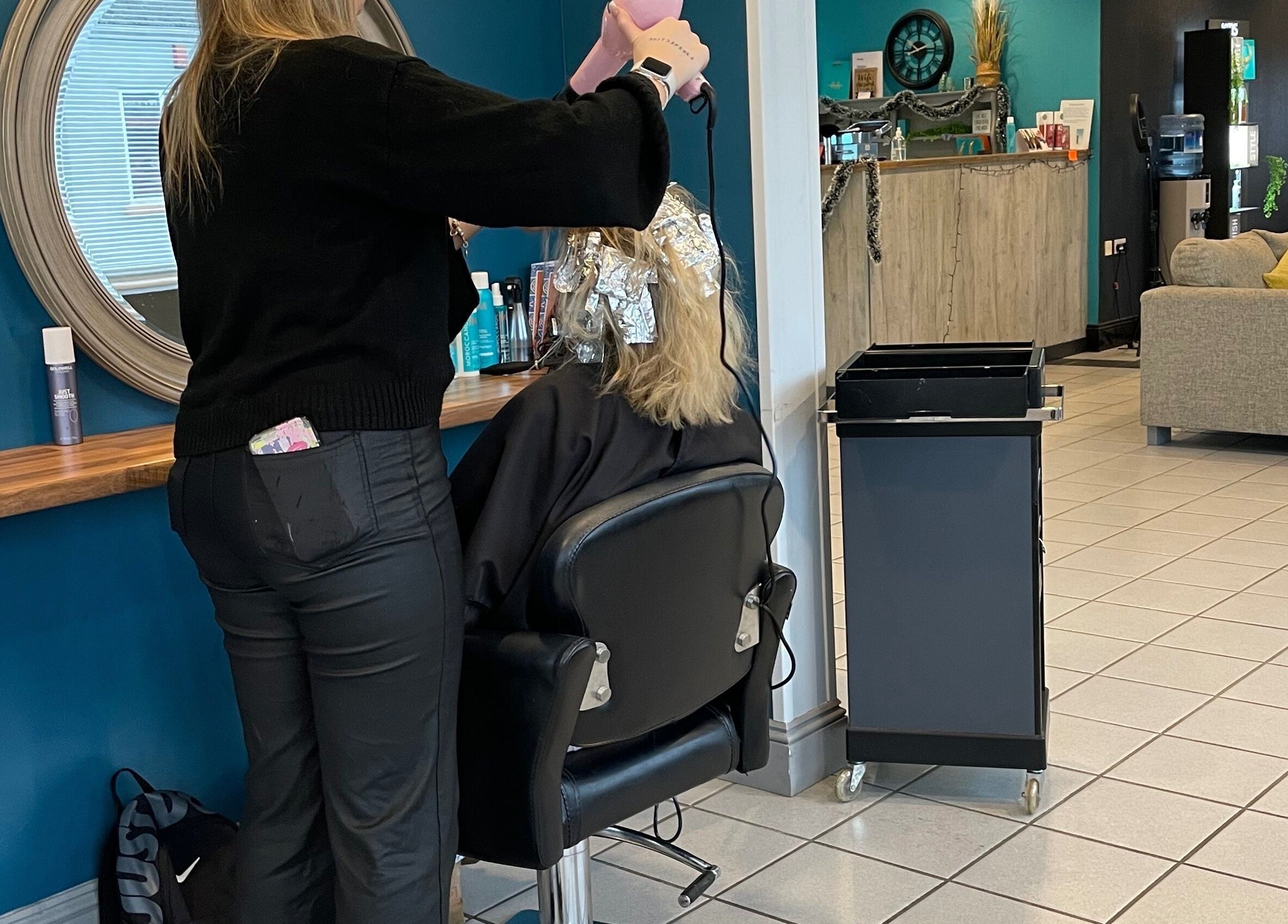 Stylist working on hair at La’torias at Kidwelly, Kidwelly, Wales, GB. Modern salon with a cozy atmosphere.