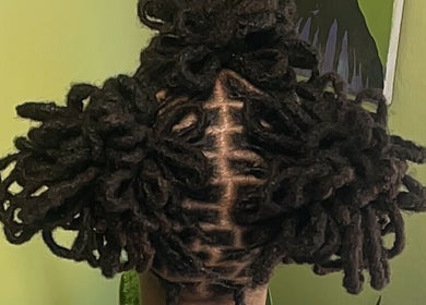 Intricate loc styling at HONEYBODY BEAUTY BAR & THE LOC HIVE, May Pen, Clarendon, JM. Vibrant green backdrop highlights.