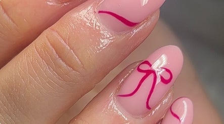 Intricate nail design with pink polish and bow detail at Beauty By Olivia Megan, Liverpool, England, GB.