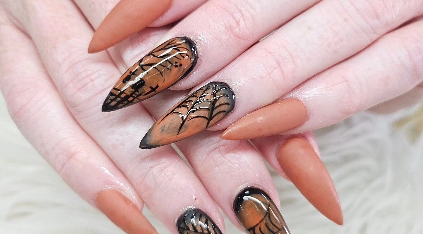 Intricate autumn-themed nail art at Nail Tip, Jacksonville, Florida, US, showcasing sharp stiletto shapes.