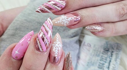 Elegant nail art at Nail Tip, Jacksonville, Florida, US, featuring pink and glitter designs with snowflakes.