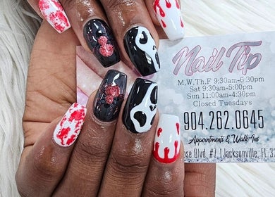 Unique nail art from Nail Tip in Jacksonville, Florida, US showcasing red and black designs on natural nails.