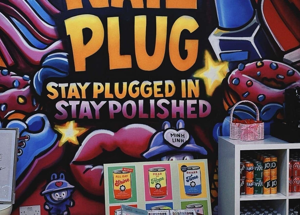 Bright graffiti decor at NailPlug in Urmston, England, GB with colorful designs and beverage display.
