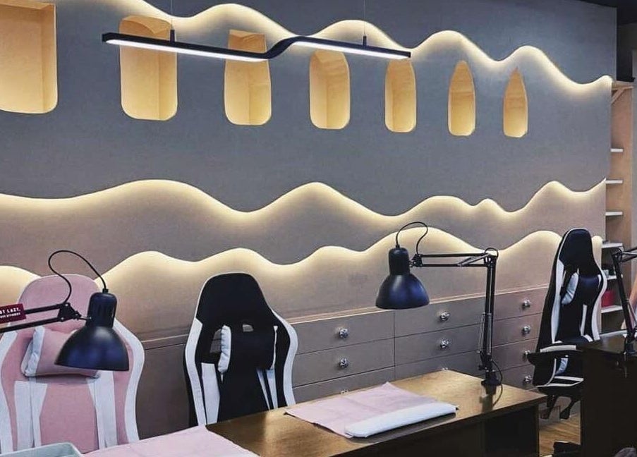 Elegant nail station at NailPlug, Urmston, England, GB with modern lighting and ergonomic chairs.