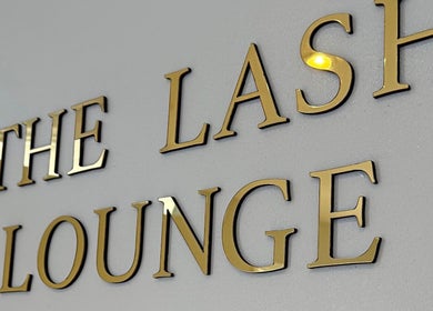 Golden lettering of THE LASH LOUNGE on a wall in Abersychan, Wales, GB.