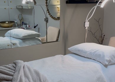 Elegant treatment room at Enhancedbeauty, Inverness, Scotland, GB, featuring plush bedding and ambient lighting.