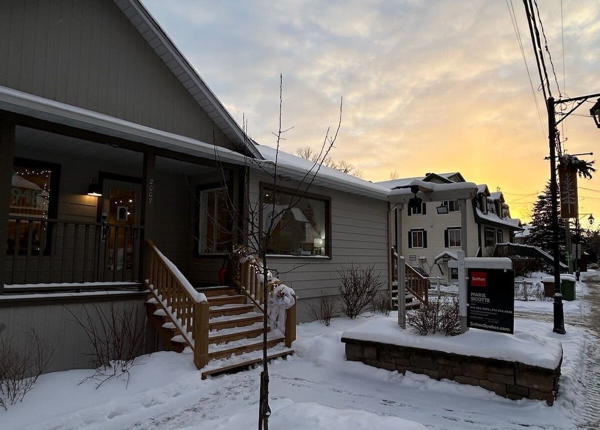 L'entrée chaleureuse de L'atelier Des Perles Tremblant à Mont-tremblant, Québec, CA, sous un ciel crépusculaire.