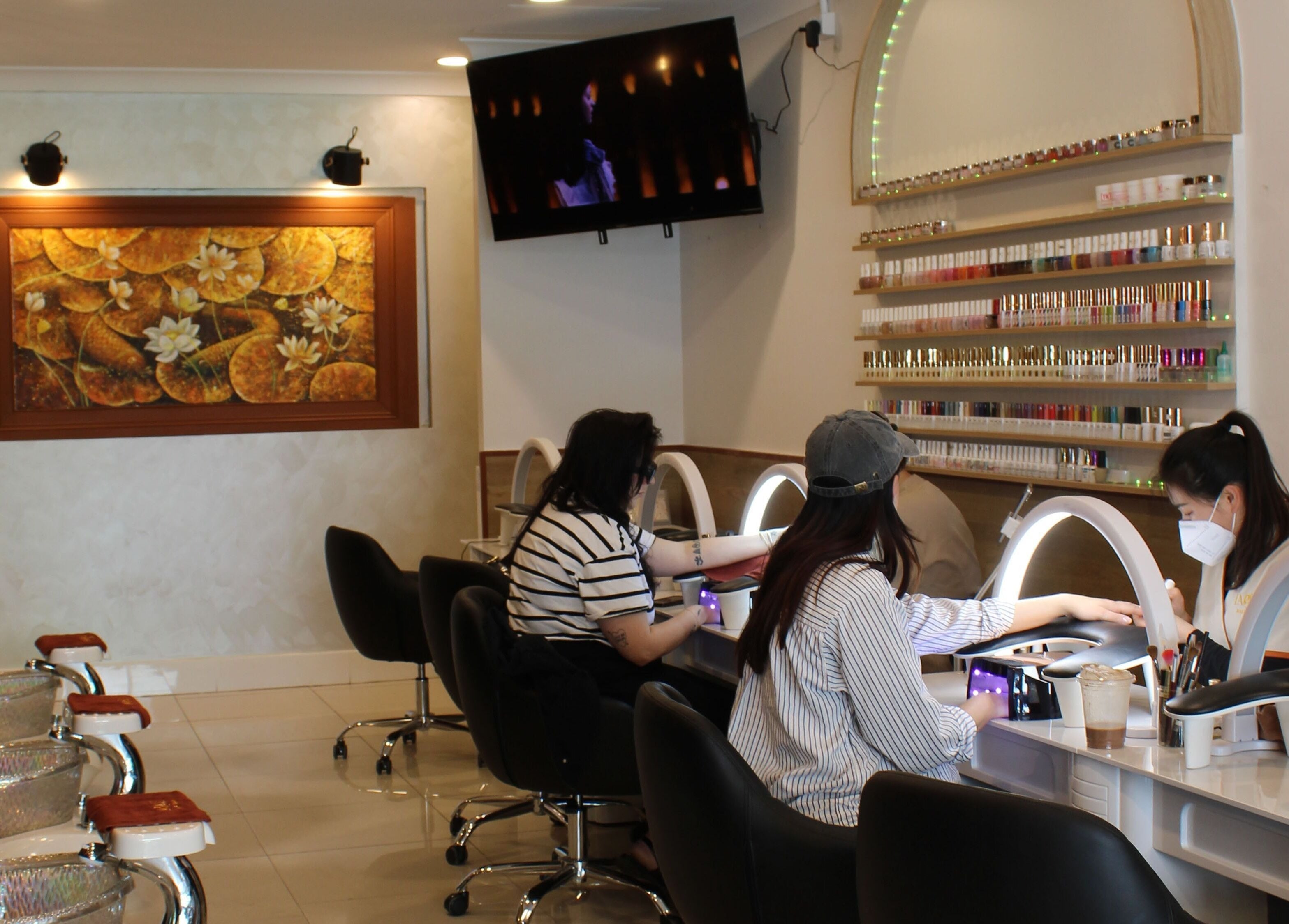 Customers enjoying manicures at Larose Nails Enmore, Enmore, New South Wales, AU, with vibrant nail polish display.