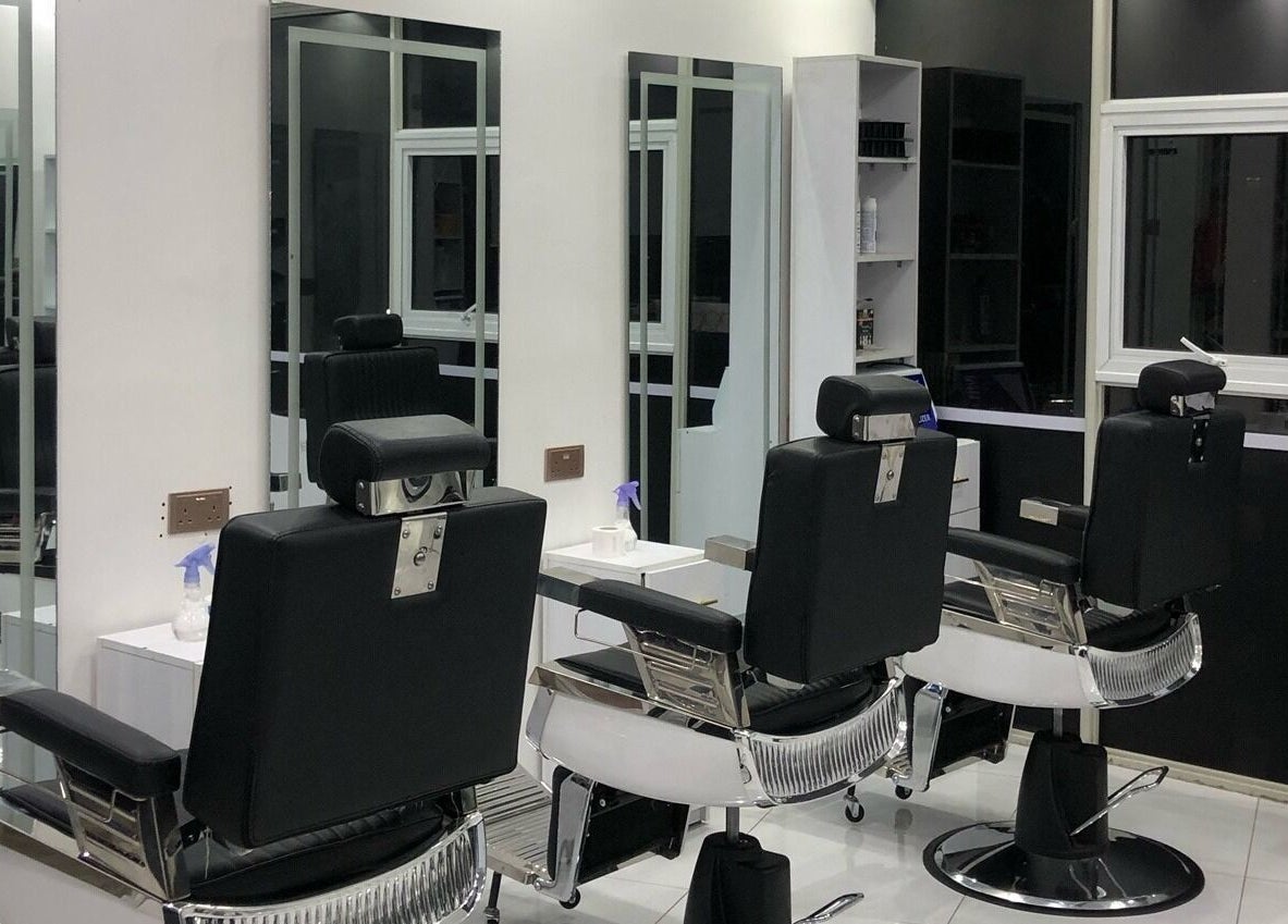 Modern interior of Artistic Grooming Parlour, Nairobi, Nairobi County, KE with sleek black barber chairs.