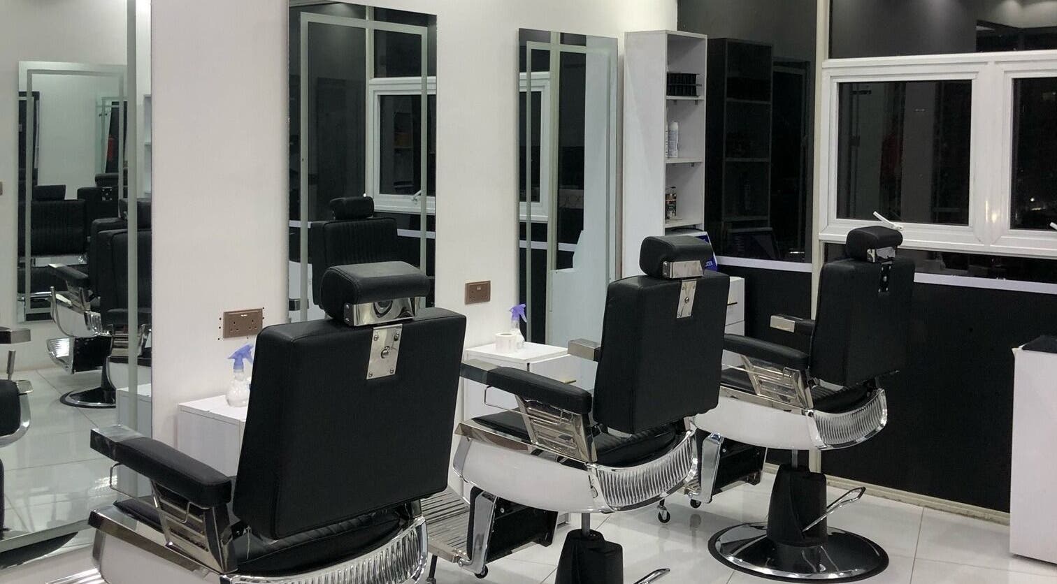 Modern interior of Artistic Grooming Parlour, Nairobi, Nairobi County, KE with sleek black barber chairs.