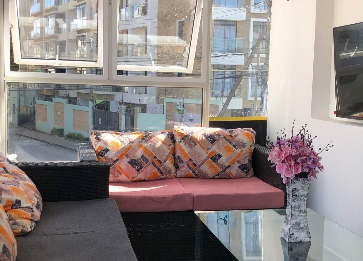 Bright lounge area at Artistic Grooming Parlour, Nairobi, Nairobi County, KE, with cushions and floral decor.