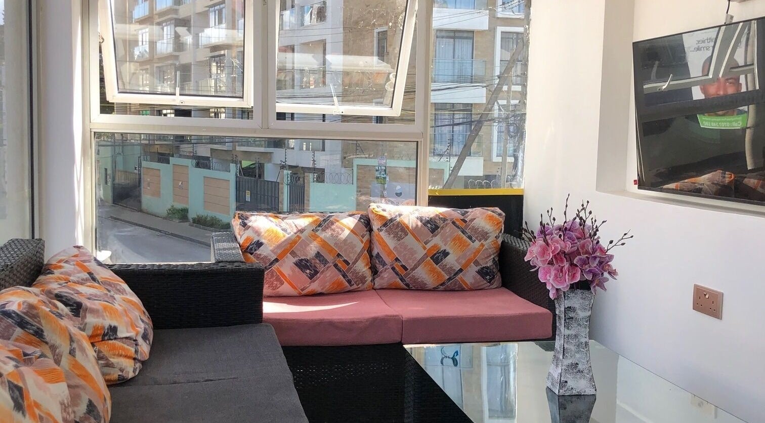 Bright lounge area at Artistic Grooming Parlour, Nairobi, Nairobi County, KE, with cushions and floral decor.