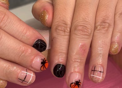 Stylish pumpkin-themed nails at nails by ariana, Jersey, JE. Glittering gold and chic patterns.