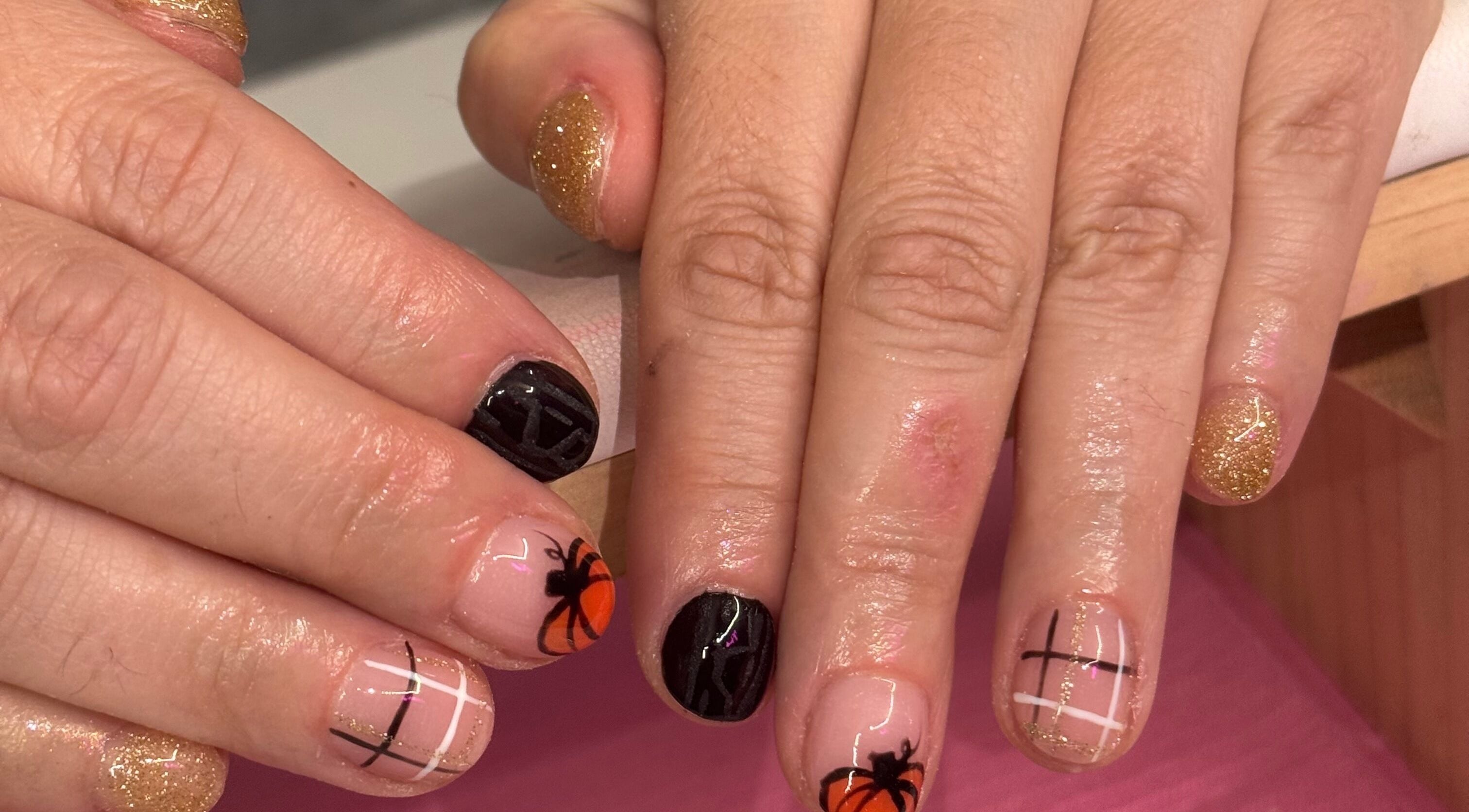 Stylish pumpkin-themed nails at nails by ariana, Jersey, JE. Glittering gold and chic patterns.