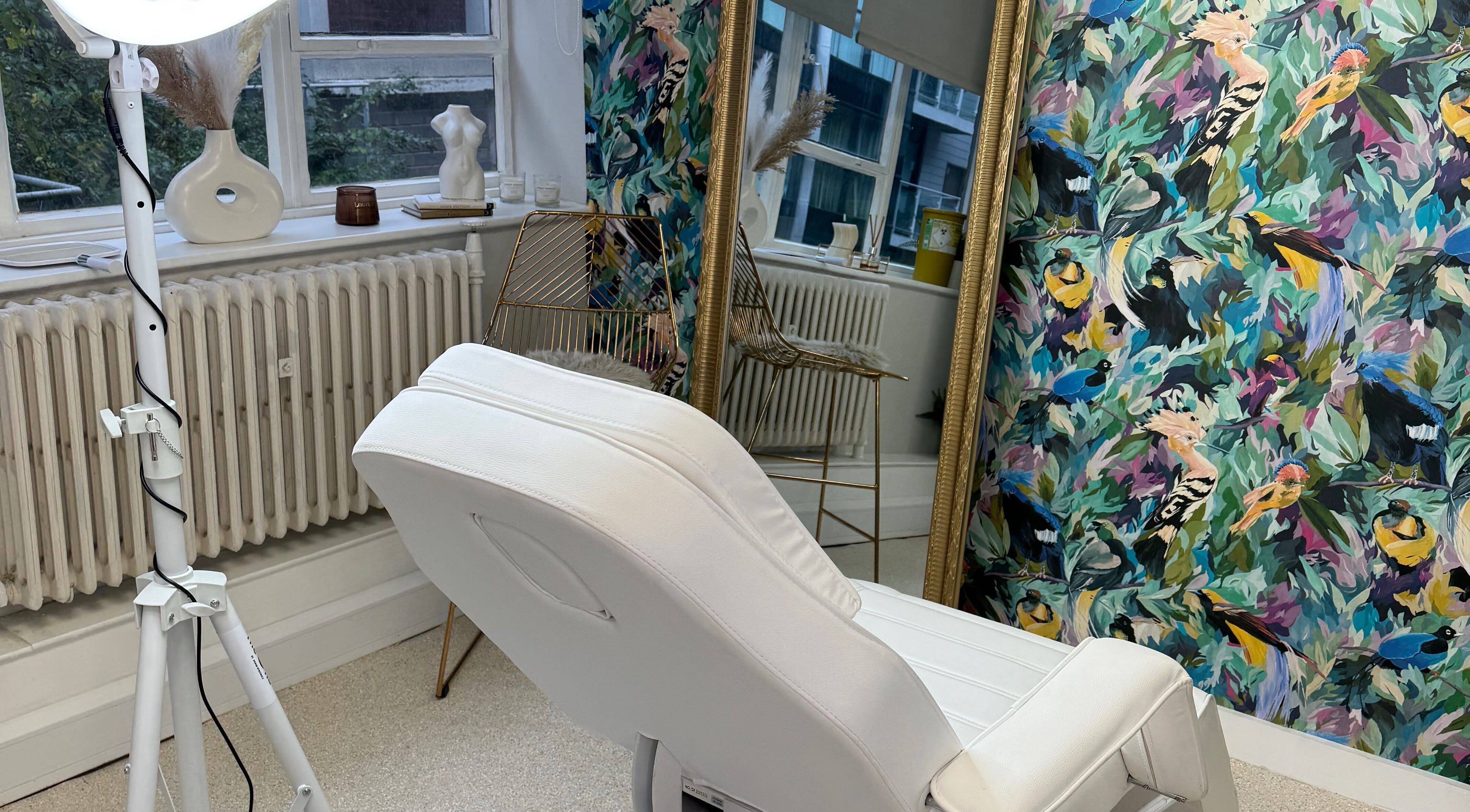 Chic beauty room with floral art at Brow de Me, Liverpool, England, GB. Elegant treatment chair and mirror decor.