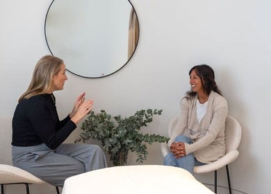 Two women in conversation at Schofield Beauty Co, Freshwater, NSW, AU. Modern and inviting ambiance.