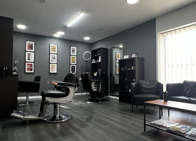 Unutrašnjost Dino’s Barber Shop, Donji Miholjac, Osječko-baranjska Županija, HR, s modernim stolicama i prostorom.