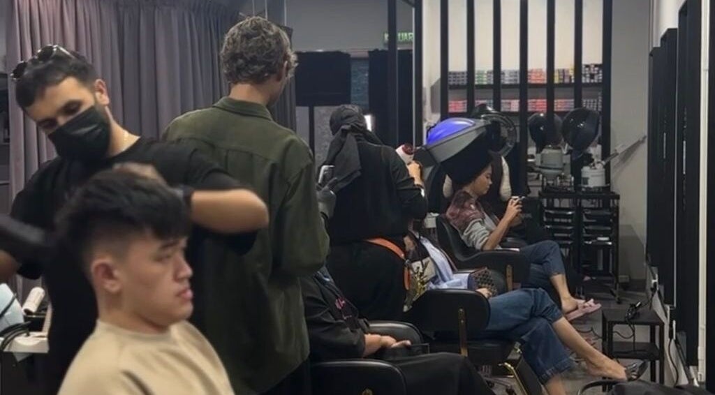 Guests enjoying hair treatments at Dee Kar Hair Salon, Cyberjaya, Selangor, MY, with attentive stylists.