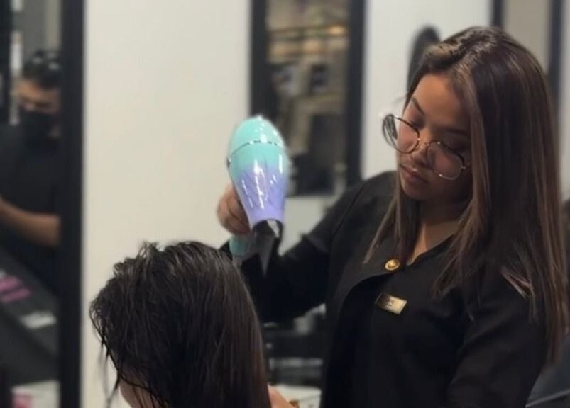 Expert stylist blow-drying hair at Dee Kar Hair Salon, Cyberjaya, Selangor, MY.