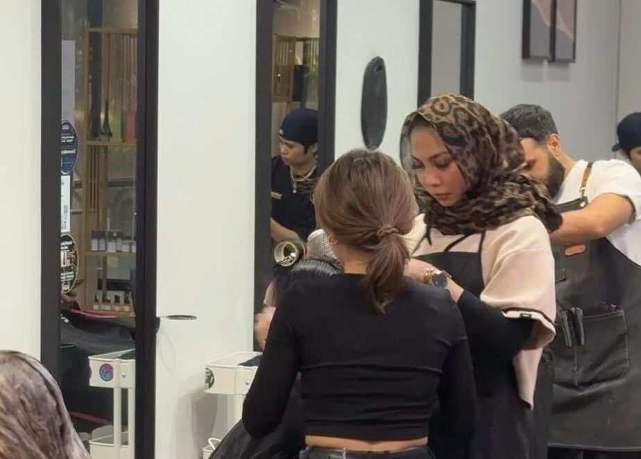 Expert stylist at Dee Kar Hair Salon in Cyberjaya, Selangor, MY, perfecting a client's look in a modern setting.