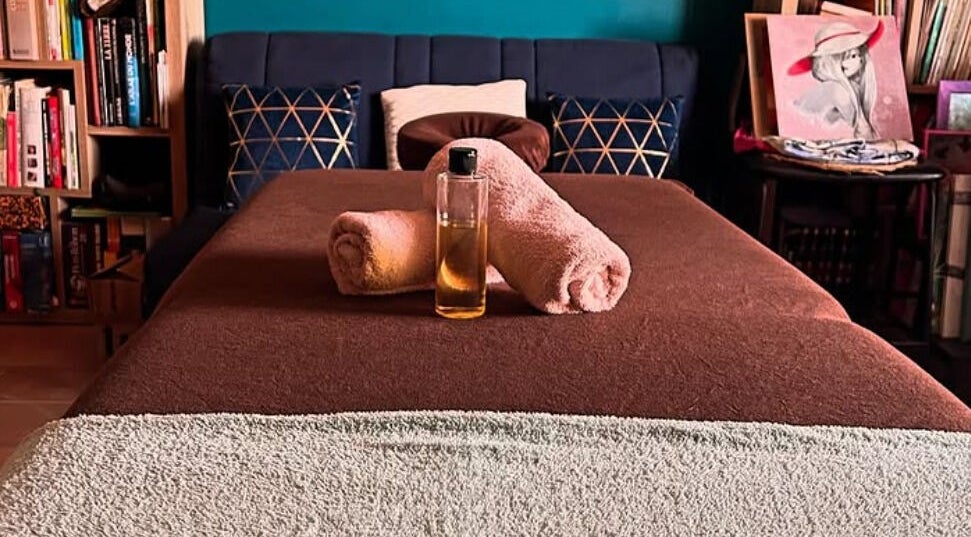 Table de massage avec serviettes et huile à Serenaya, Montauban, Occitanie, FR.