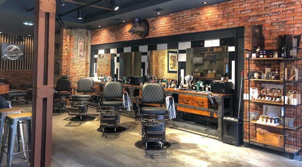 Interior clásico de Chamorro Barber Shop en Oviedo, ES con sillas de barbero y decoración vintage.