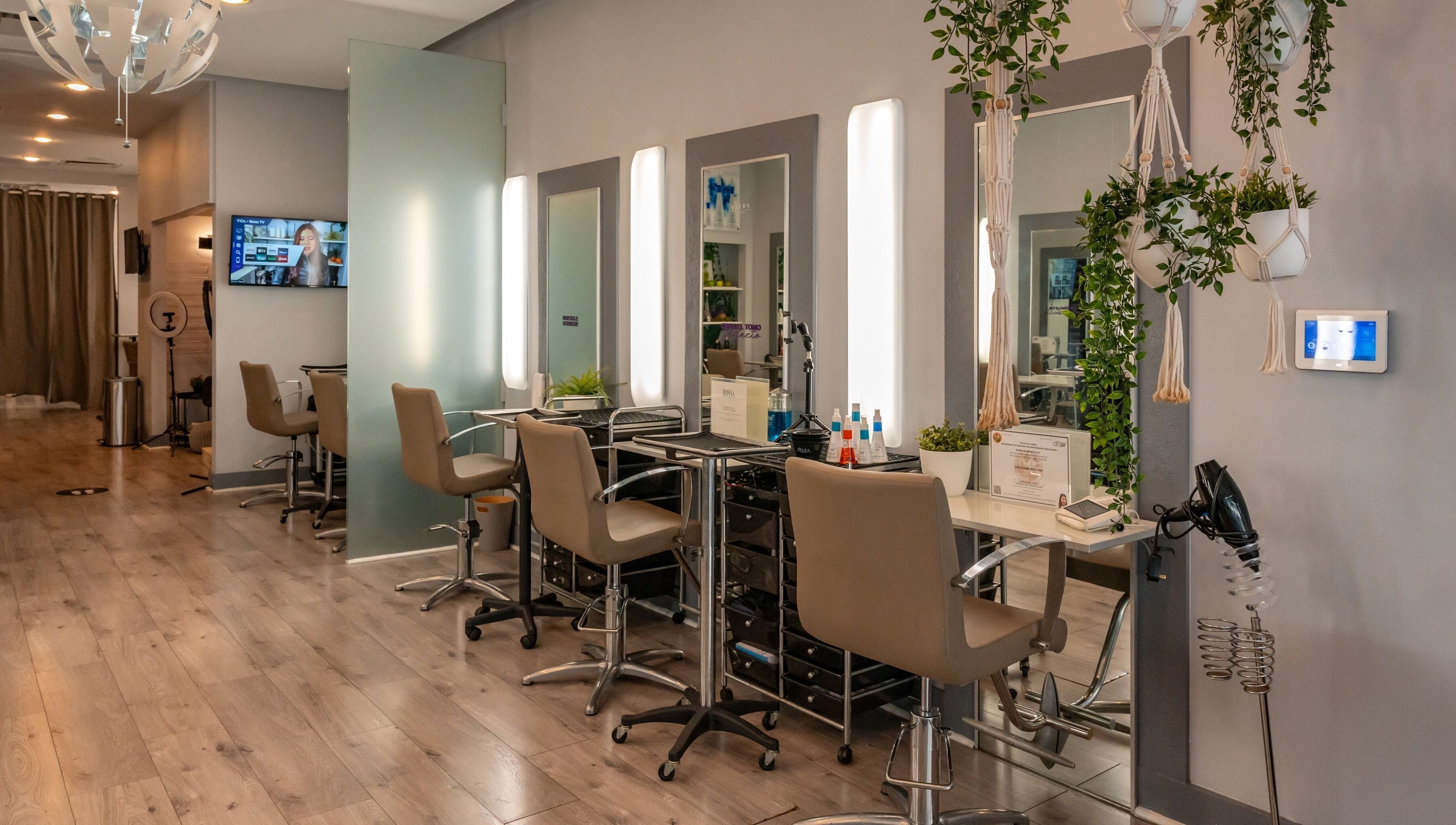 Interior moderno del BOSSA HAIR SALON LLC en Coral Gables, Florida, US. Estaciones de peinado bien iluminadas.