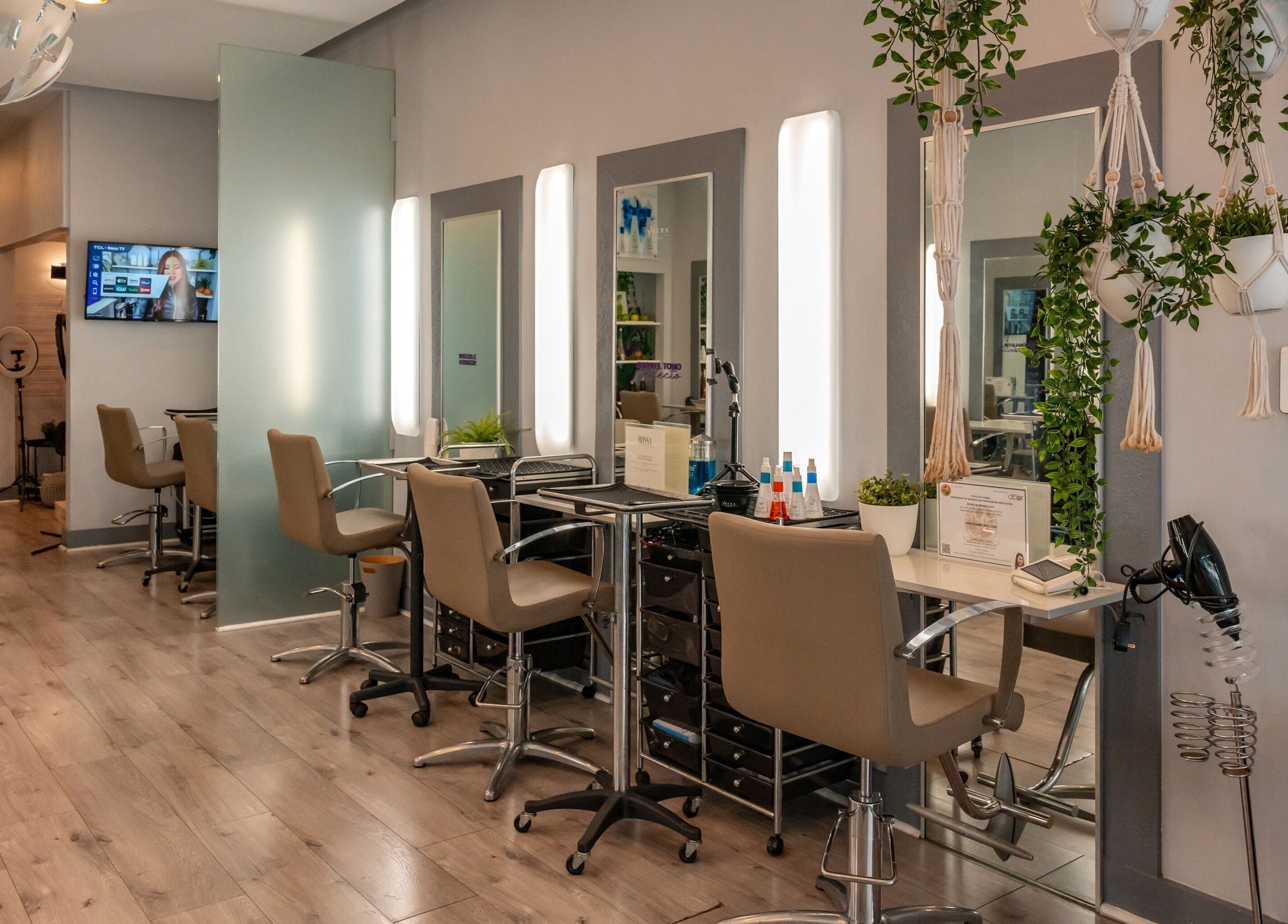 Interior moderno del BOSSA HAIR SALON LLC en Coral Gables, Florida, US. Estaciones de peinado bien iluminadas.