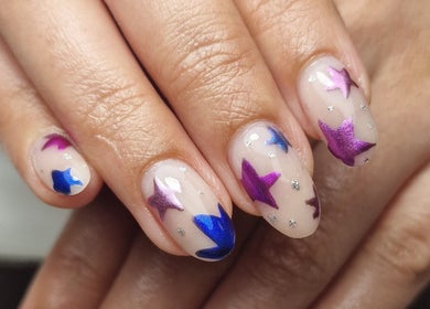 Colorful star nail art by Gels By Kana in Walsall, England, GB showcases purple and blue designs.