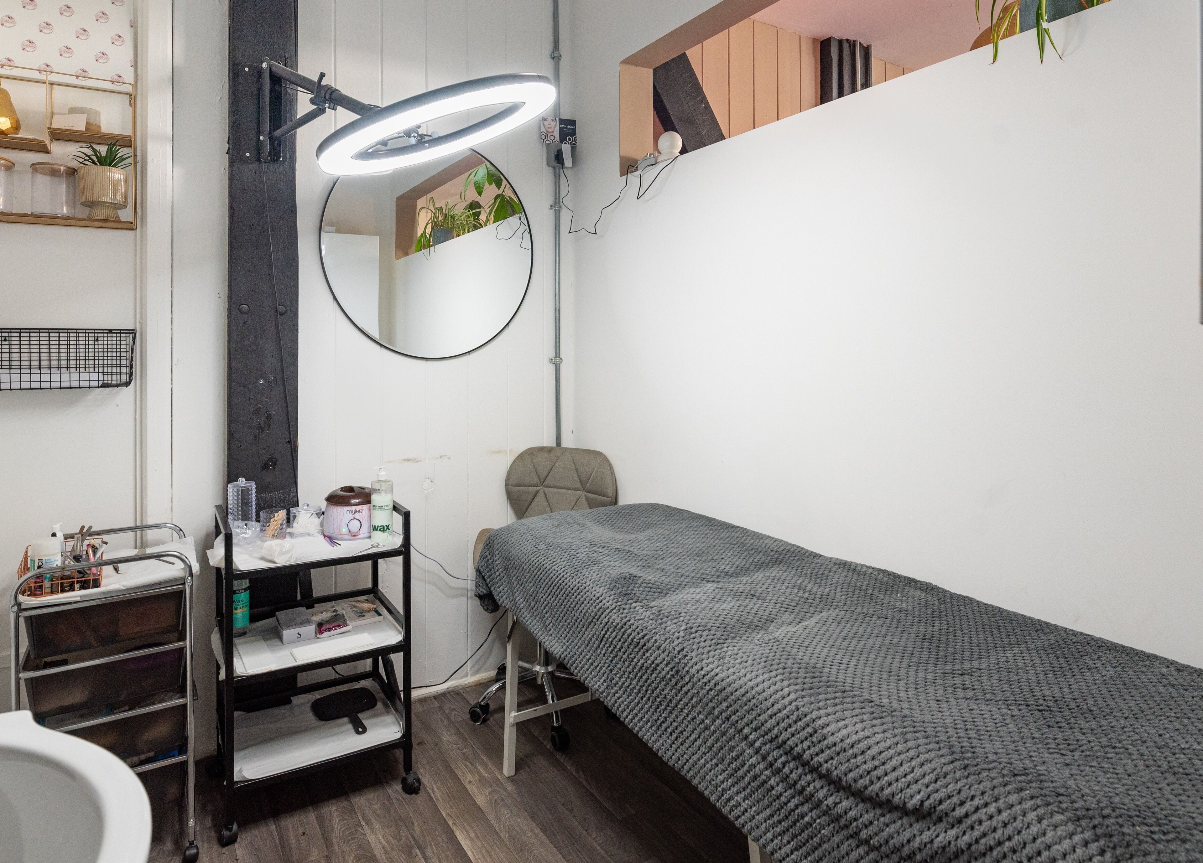 Relaxing treatment room at Sosta, Ash, England, GB with a cozy bed and sleek decor.