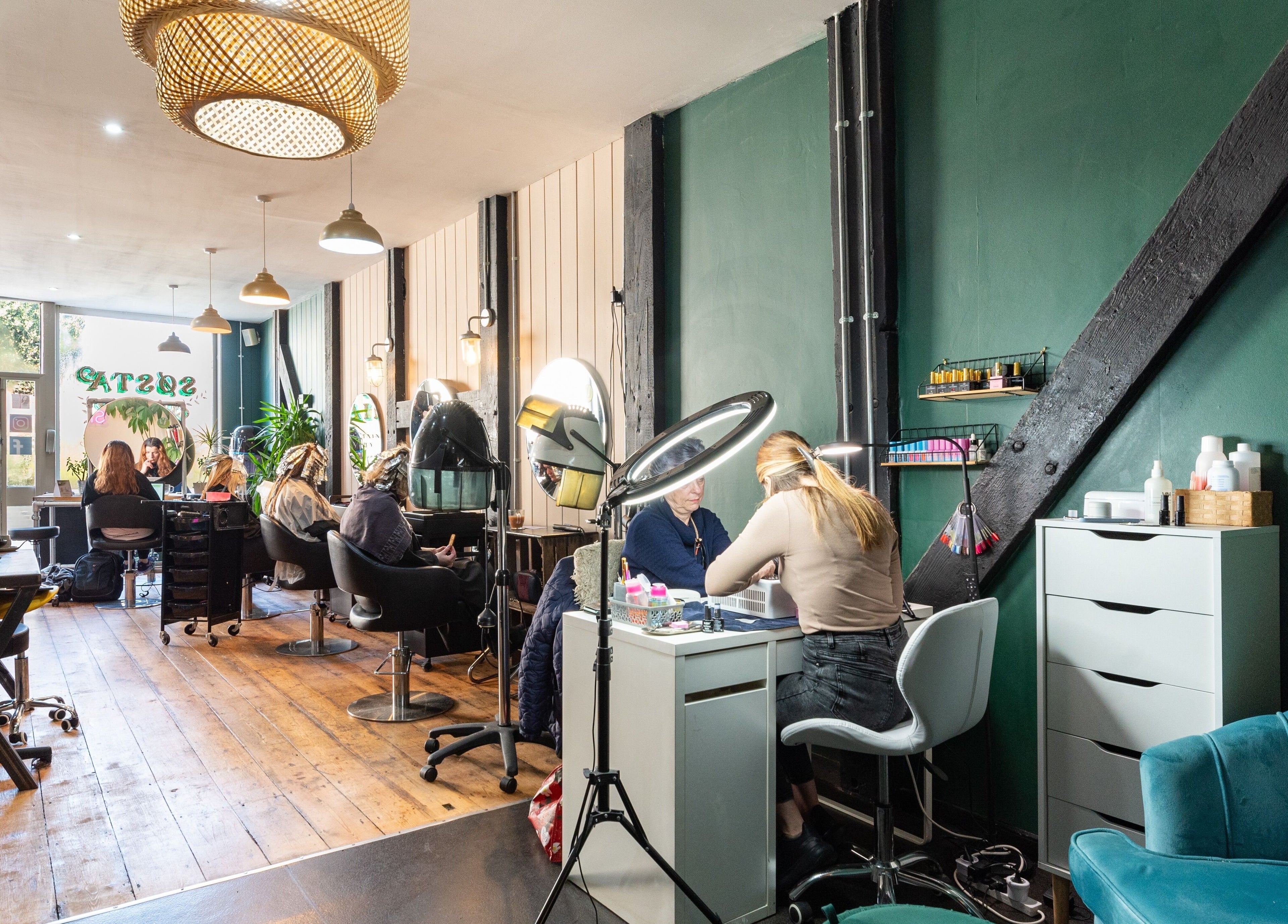 Inside Sosta in Ash, England, GB showing elegant salon setup with clients receiving services.