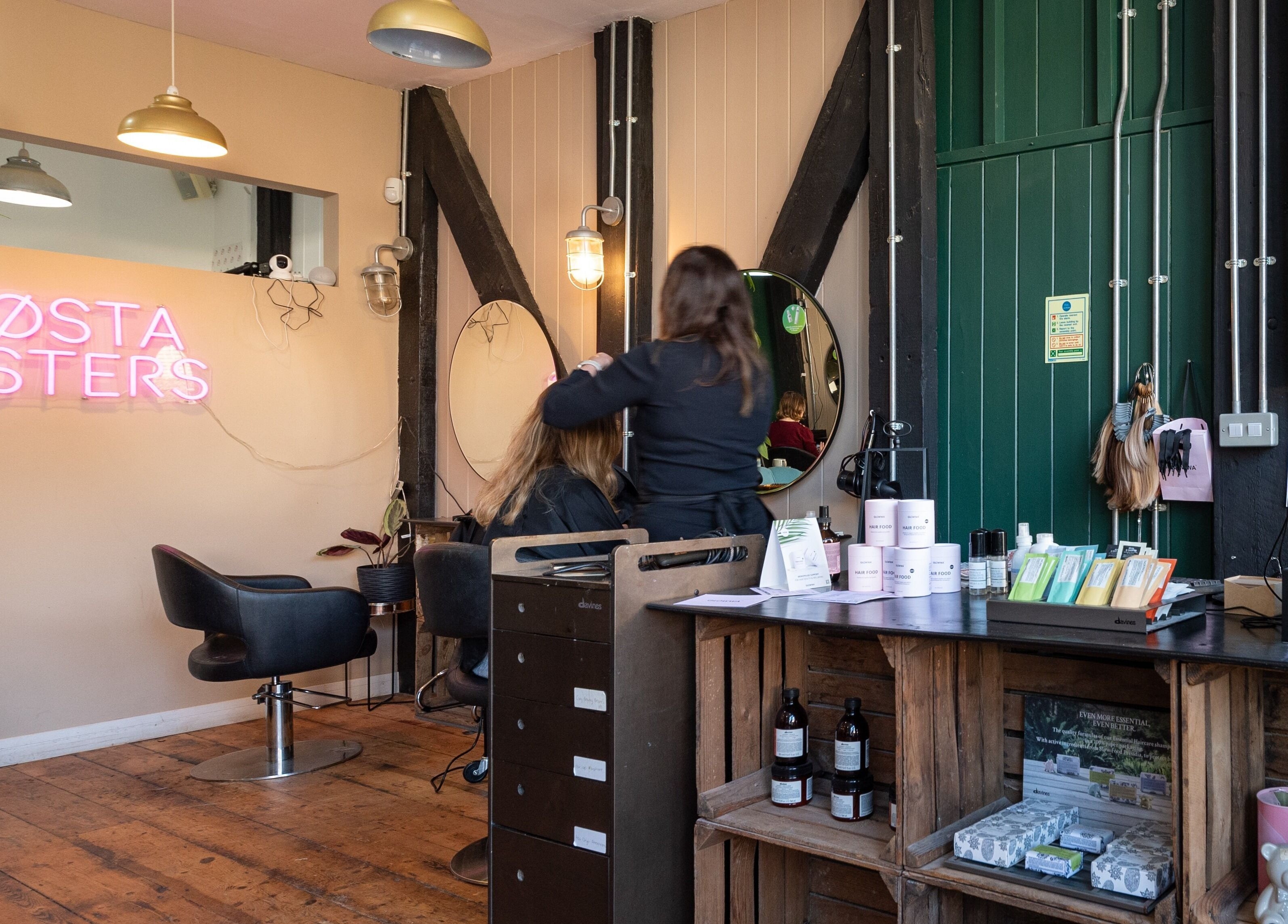 Inside Sosta salon in Ash, England, GB with modern chairs and neon sign.