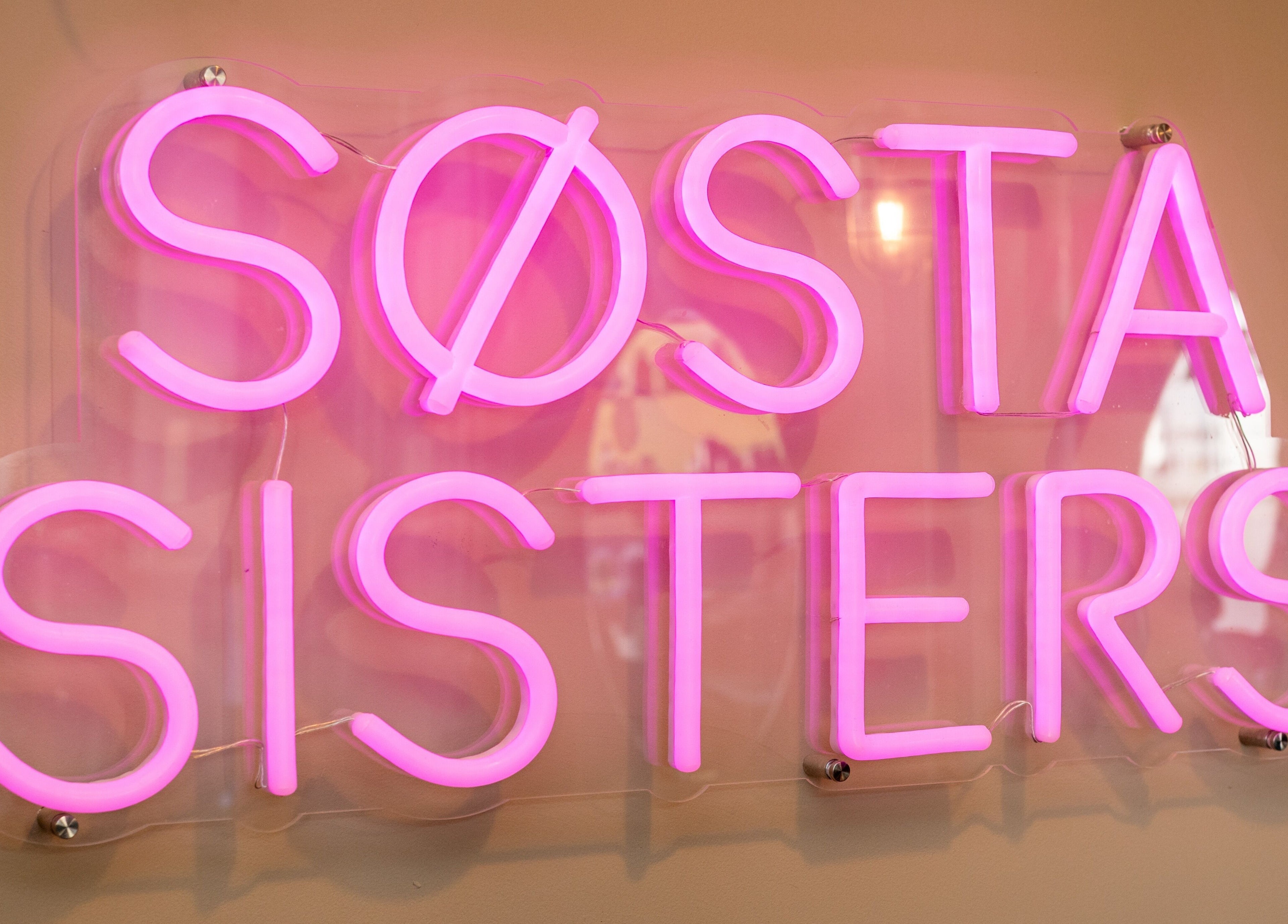 Bright pink 'Sosta Sisters' neon sign at Sosta, Ash, England, GB.