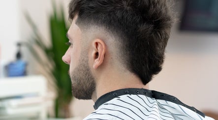 A man with a fresh haircut at ST8MNT Barbers in Gibraltar, GI, showcasing expert barbering skills.