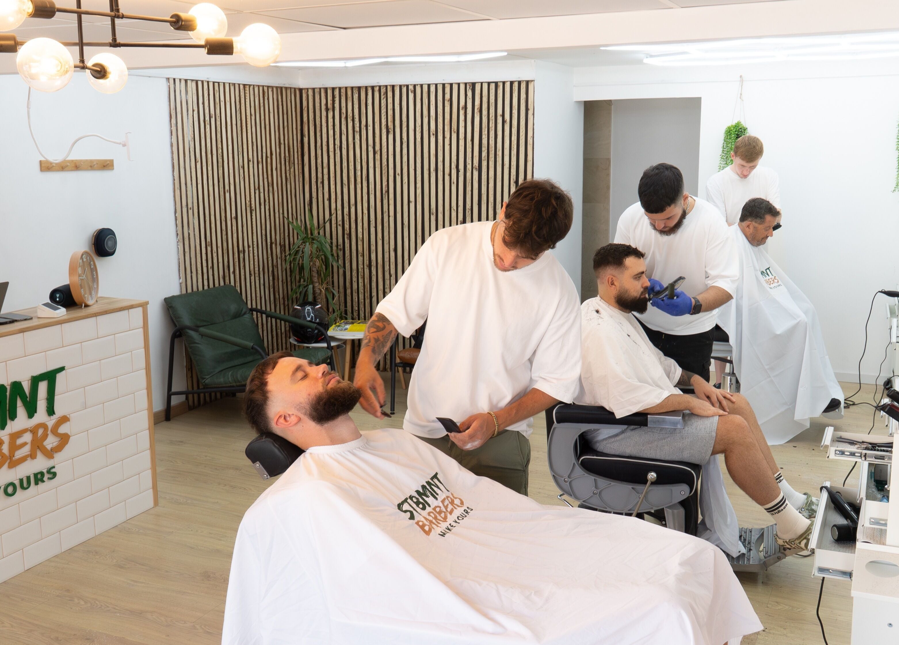 ST8MNT Barbers interior, stylists at work in Gibraltar, GI. Cozy and modern.