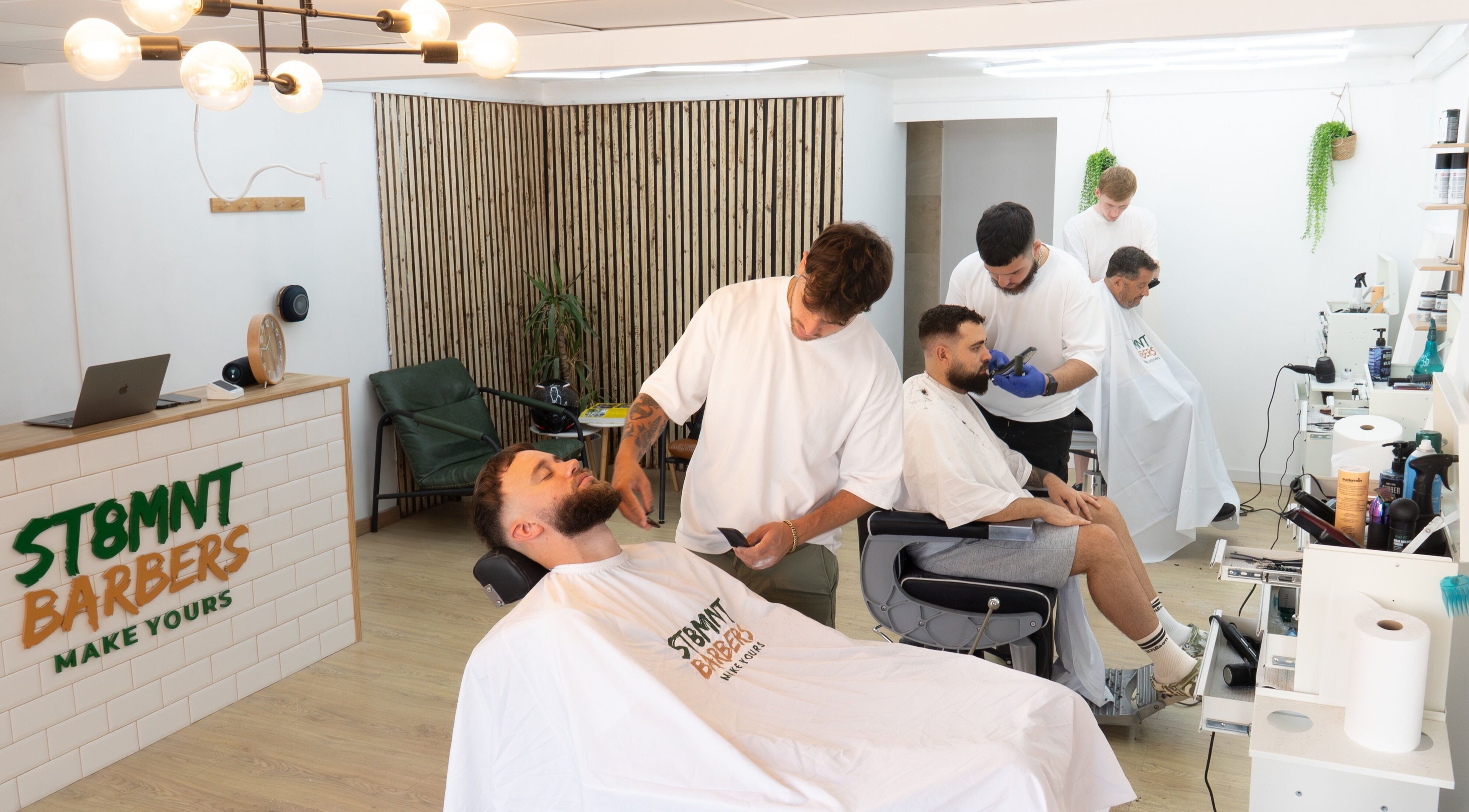 ST8MNT Barbers interior, stylists at work in Gibraltar, GI. Cozy and modern.