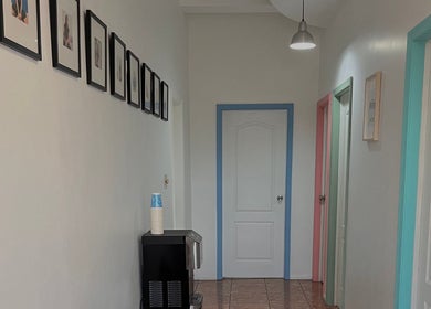 Pasillo colorido en Minds and Smiles, Playas De Rosarito, Baja California, MX, con fotos enmarcadas y puertas.