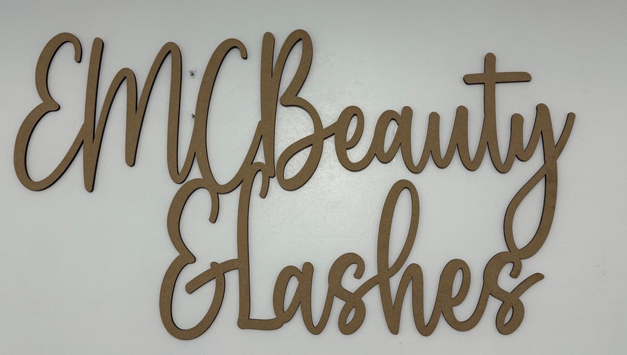Wooden sign of EMC Beauty And Lashes in Poyntzpass, Northern Ireland, GB on a white background.