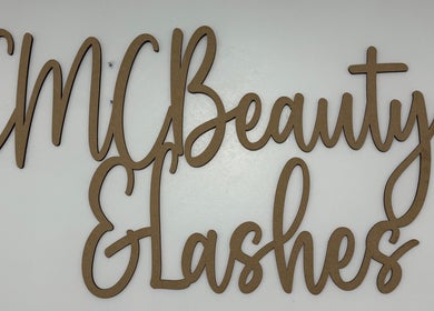 Wooden sign of EMC Beauty And Lashes in Poyntzpass, Northern Ireland, GB on a white background.