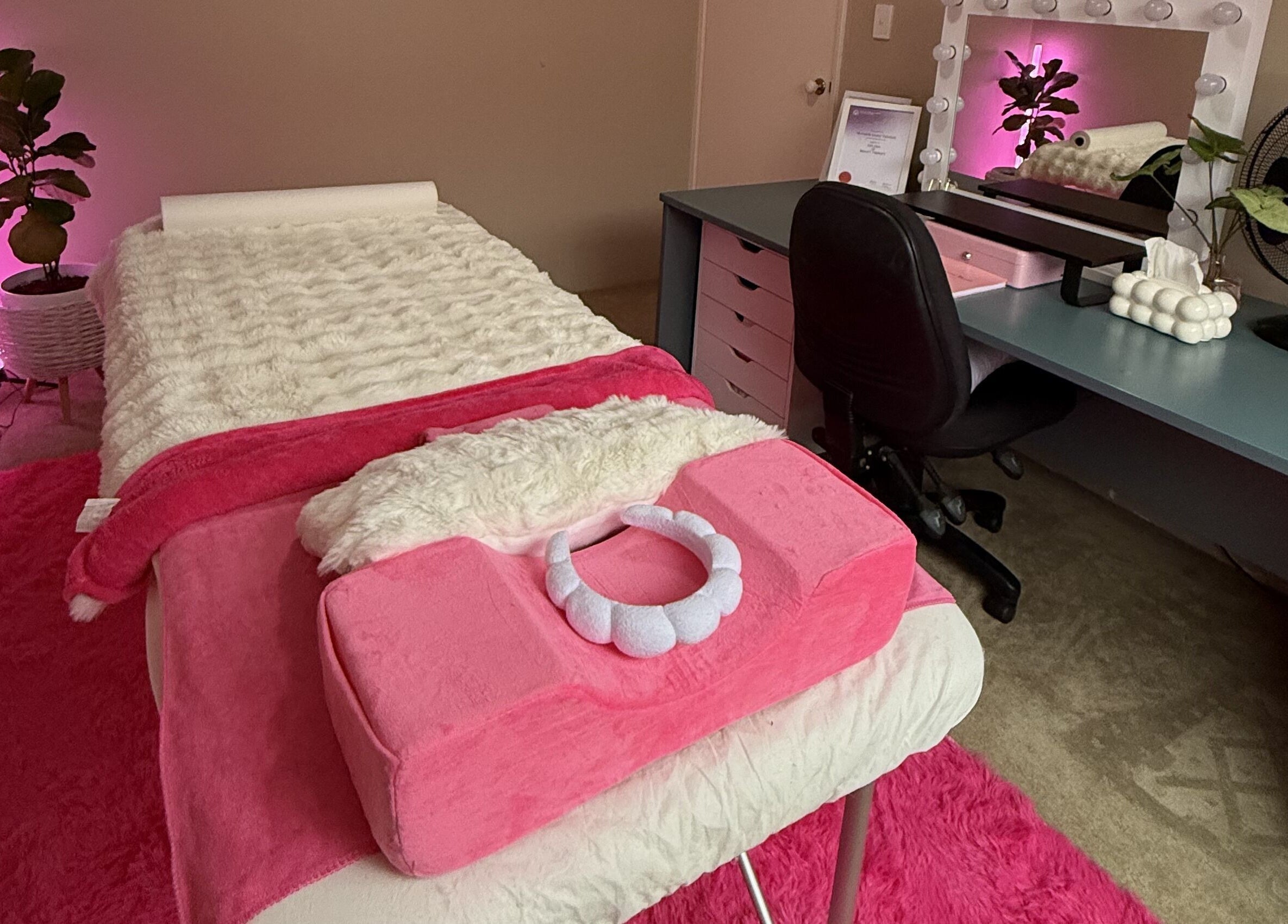 Relaxing treatment room at Baddie Beauty, Wannanup, Western Australia, AU with pink decor and comfy massage bed.