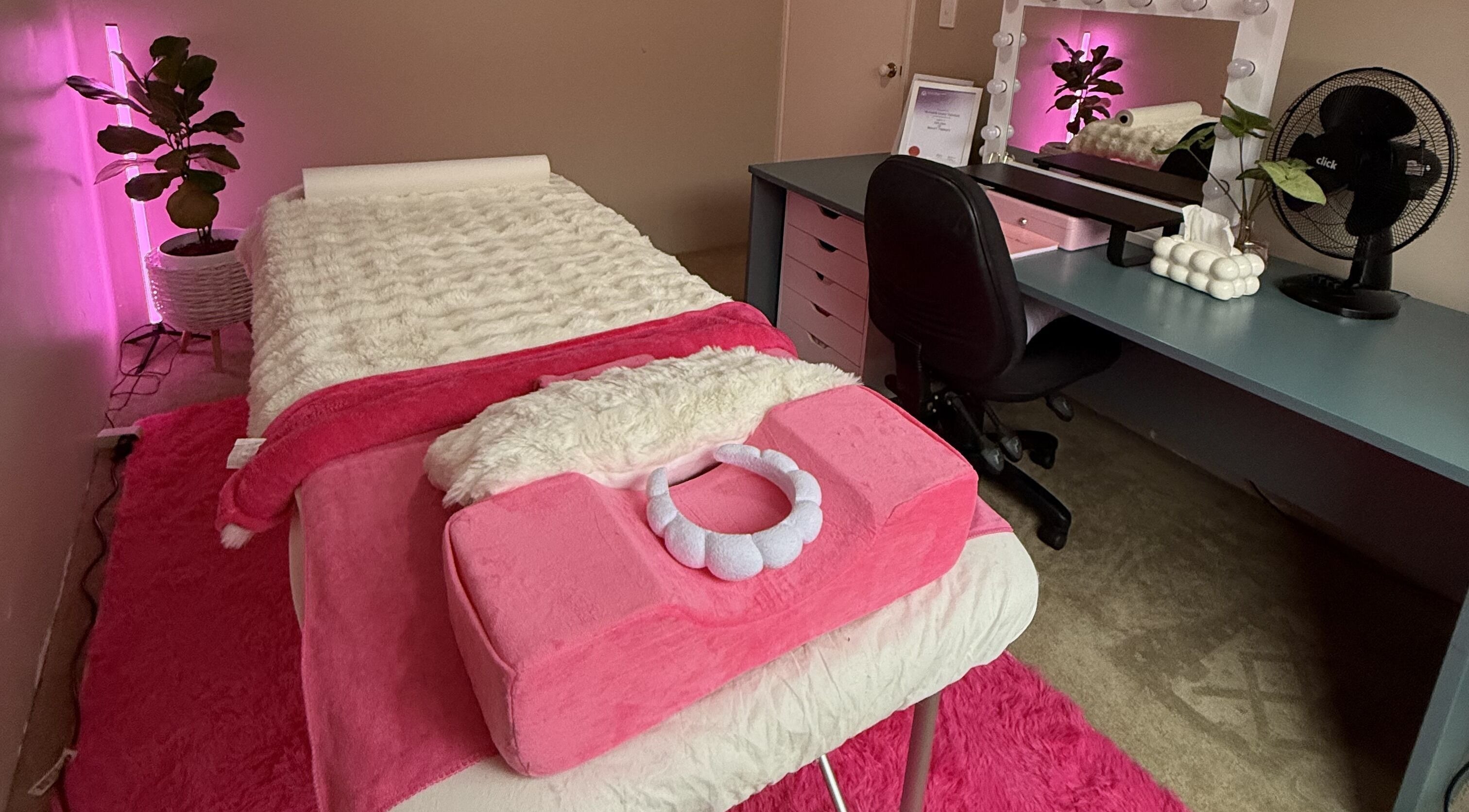 Relaxing treatment room at Baddie Beauty, Wannanup, Western Australia, AU with pink decor and comfy massage bed.