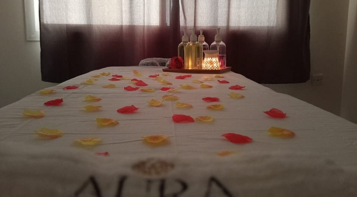 Massage table with rose petals and oils at Aura Beauty Massage, Doha, Doha Municipality, QA.