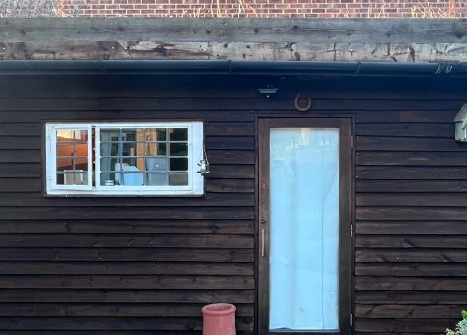 Rustic cabin exterior of Cabin Barbers in Chessington, England, GB with vintage wooden facade and cozy window view.