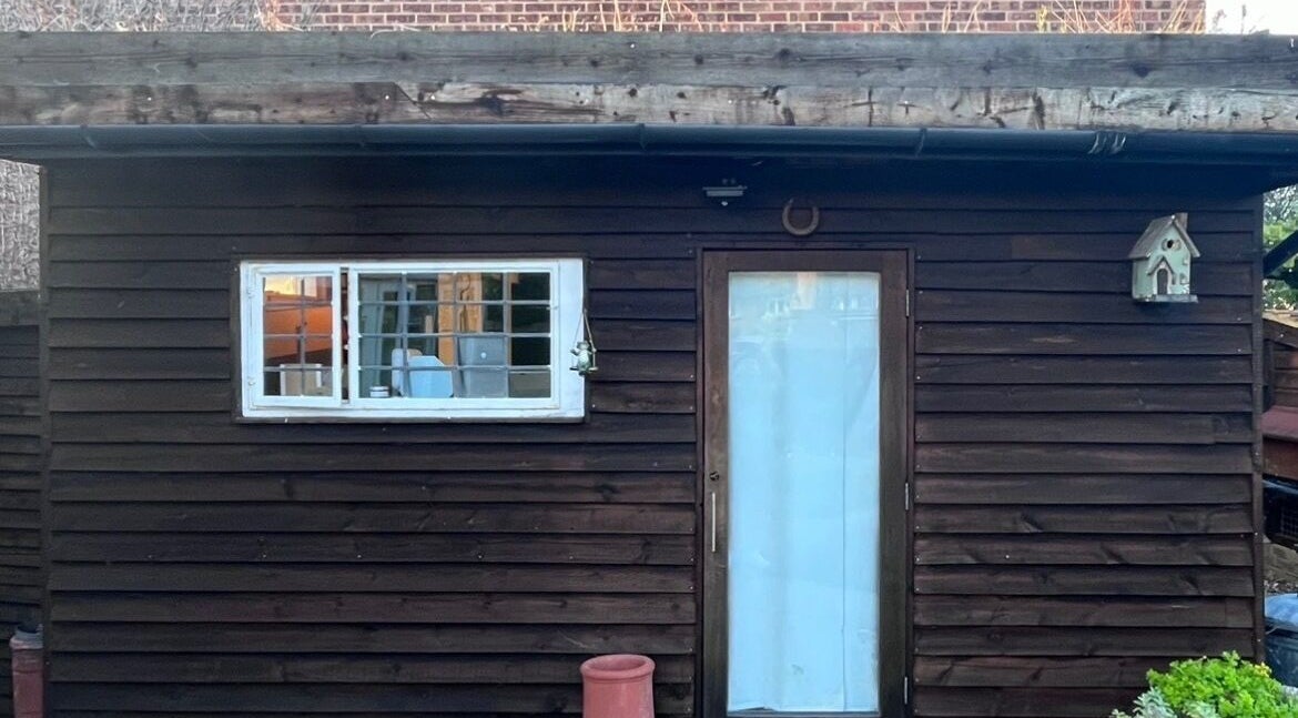 Rustic cabin exterior of Cabin Barbers in Chessington, England, GB with vintage wooden facade and cozy window view.