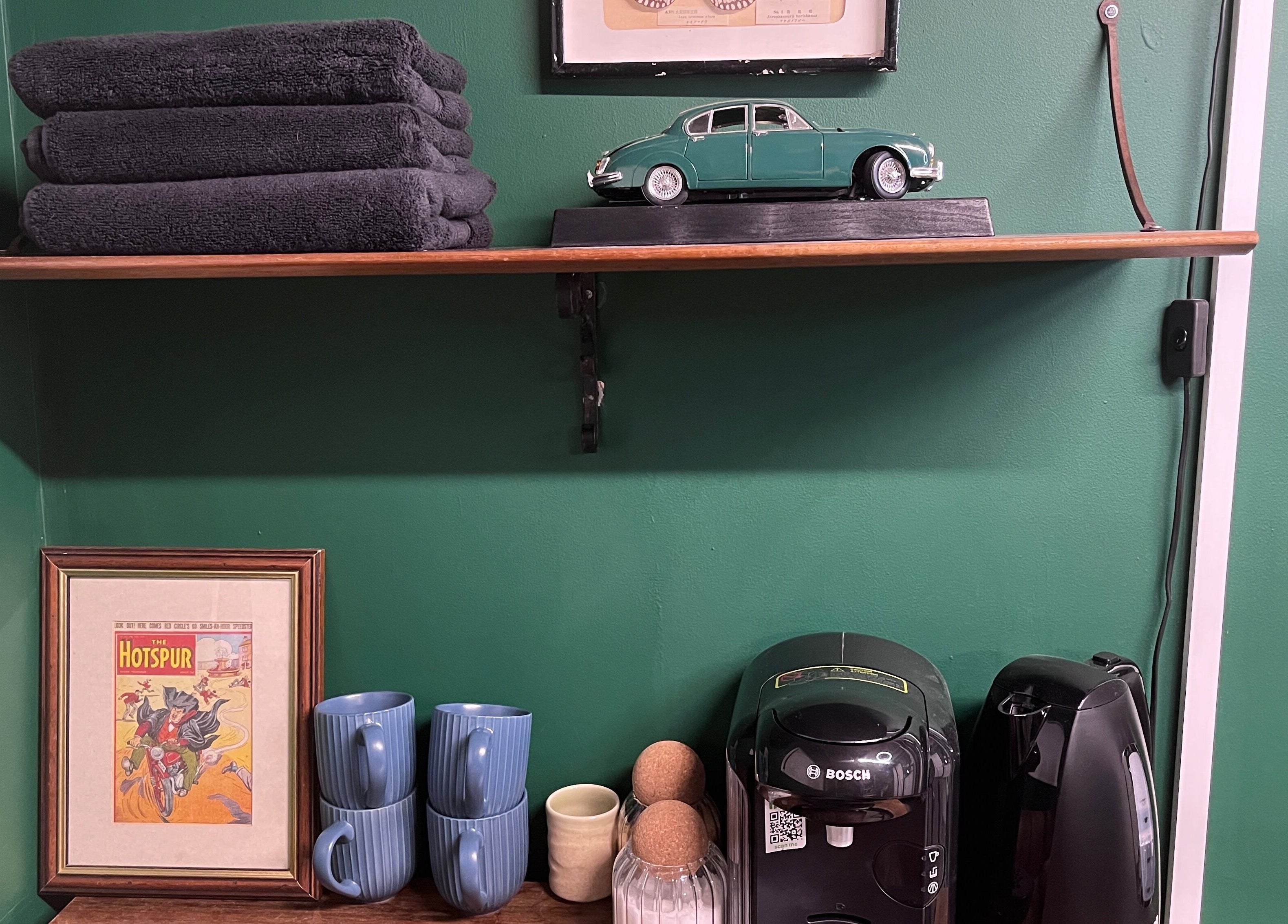 Cabin Barbers in Chessington, England, GB features a cozy decor with vintage art, towels, and a coffee maker.