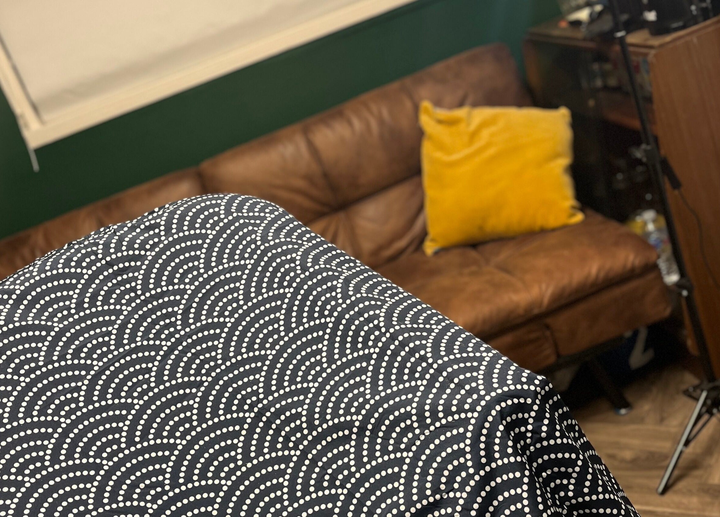 Cozy seating area at Cabin Barbers in Chessington, England, GB with patterned cover and yellow cushion.