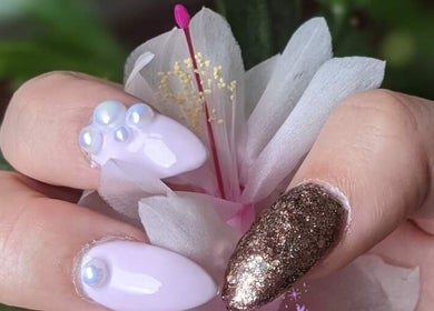 Elegant nail art with pearls at Enchanted Nails, Kelowna, British Columbia, CA, showcasing a chic floral background.