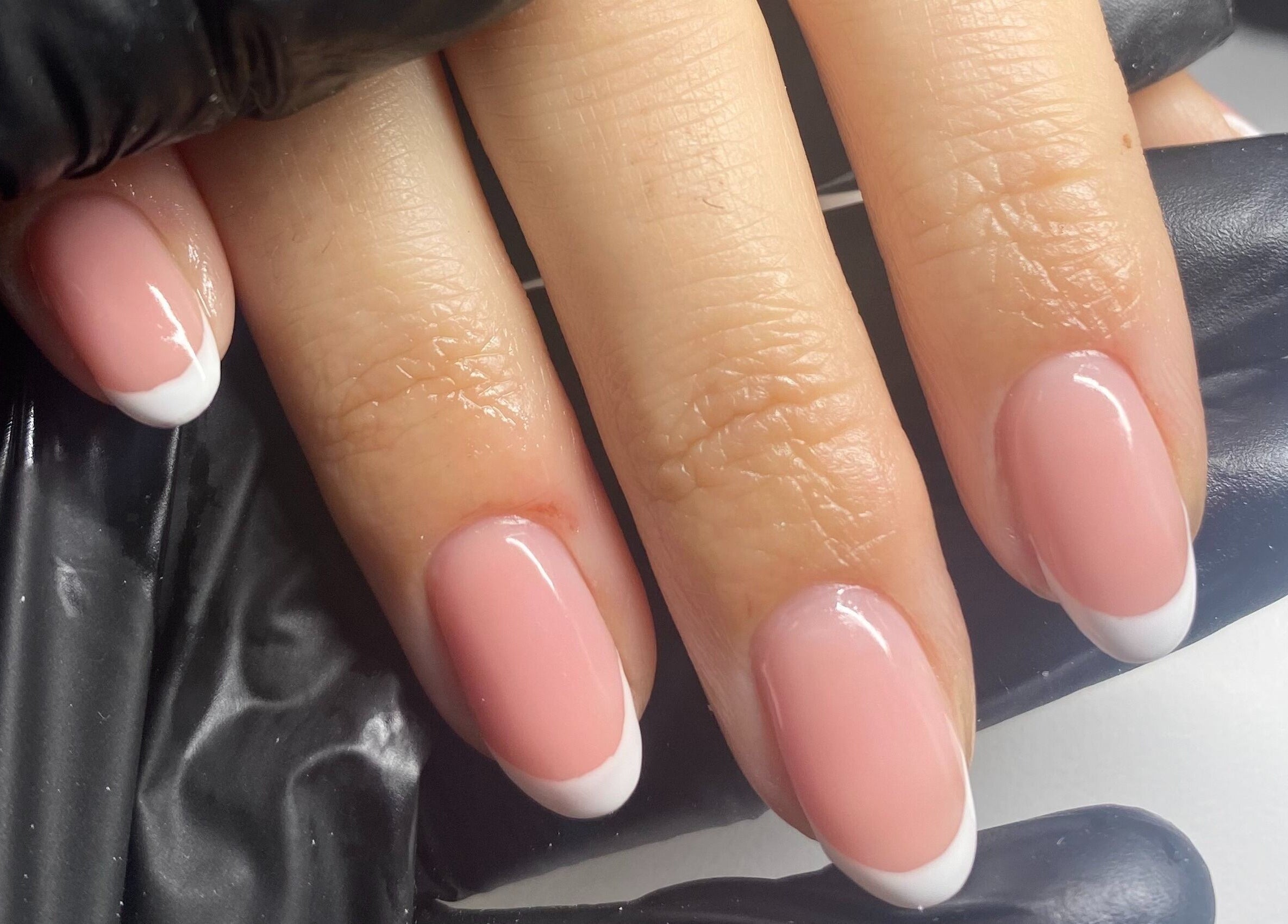 Elegant French manicure at Cure The Nail Studio, Oswestry, England, GB, showcasing glossy pink nails with white tips.
